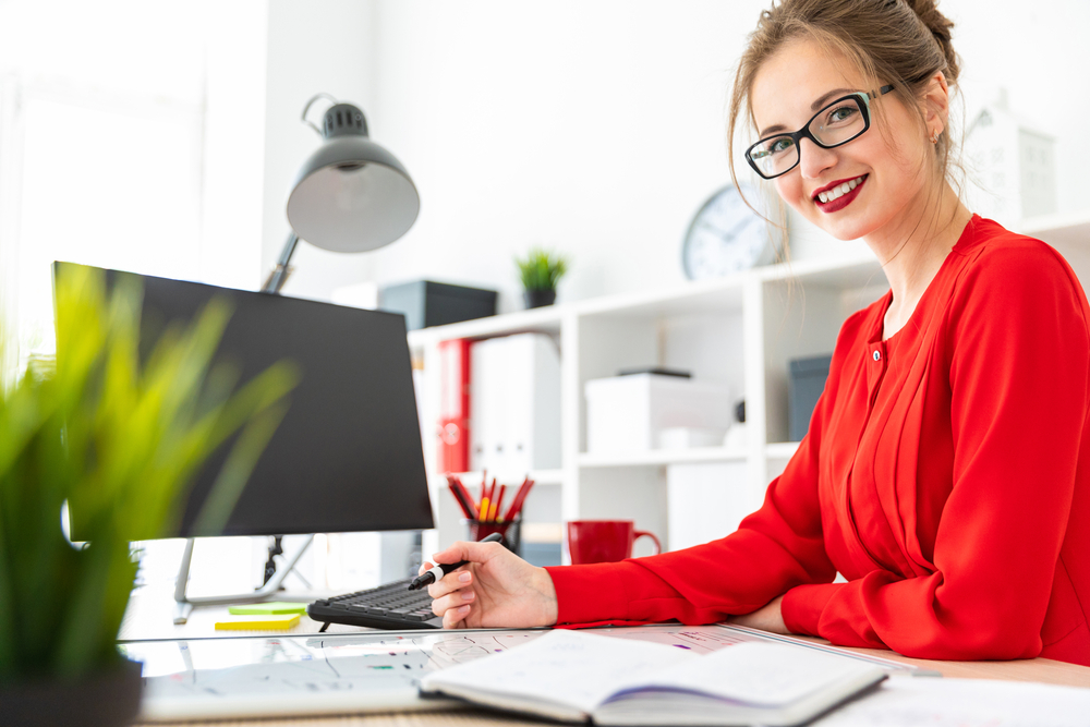 business strategy  woman in red top at desk smiling